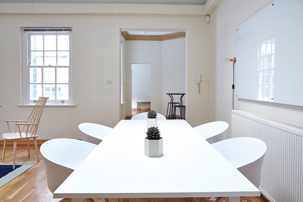 A meeting room with a long table and chairs