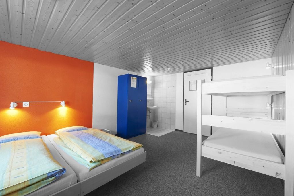 A guest room with a large bed and soft lighting