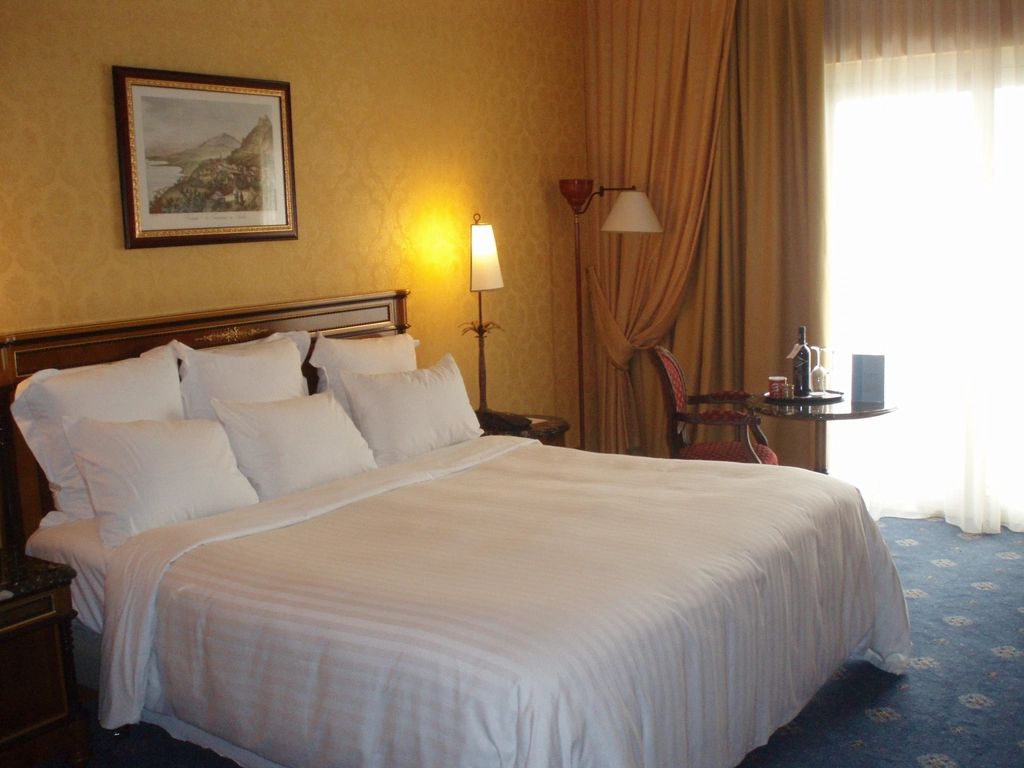 A guest room with a large bed and soft lighting